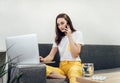 Asian woman talking on mobile phone and using laptop. Working from home Royalty Free Stock Photo