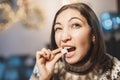 Woman tastes and nibbles a piece of white refined sugar. The concept of excessive consumption of fast carbohydrates and