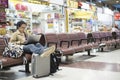 Asian woman teenager using smartphone at airport terminal sittin Royalty Free Stock Photo