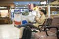 Asian woman teenager using smartphone and laptop at airport term Royalty Free Stock Photo