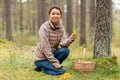 asian woman with thermos drinking tea in forest