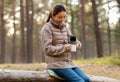 asian woman with thermos drinking tea in forest