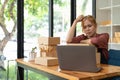 Asian woman think hard serious working laptop computer at home selling online start up small business owner, e-commerce Royalty Free Stock Photo