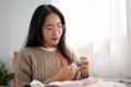 An Asian woman is threading at home, choosing a thread for her handcraft Royalty Free Stock Photo