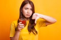 Asian woman thumbs down hate tomato juice in yellow dress Royalty Free Stock Photo