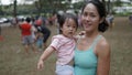 Asian woman and toddler participating in family games outdoor