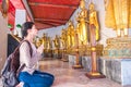 Asian women tourist backpack is worshiping the image of Buddha in holiday at wat pho Bangkok Thailand. It is a landmark and Royalty Free Stock Photo