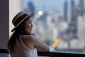 Asian woman tourist enjoying her urban city skyline from the hotel room balcony for vacation and travel concept Royalty Free Stock Photo