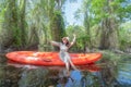 Asian woman, a tourist, paddling a boat, canoe or kayak with trees in Rayong Botanical Garden, Paper Bark Tropical Forest in Royalty Free Stock Photo