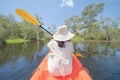 Asian woman, a tourist, paddling a boat, canoe or kayak with trees in Rayong Botanical Garden, Paper Bark Tropical Forest in Royalty Free Stock Photo