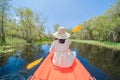 Asian woman, a tourist, paddling a boat, canoe or kayak with trees in Rayong Botanical Garden, Paper Bark Tropical Forest in Royalty Free Stock Photo