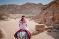 Asian woman tourist riding donkey in Petra, Jordan Royalty Free Stock Photo