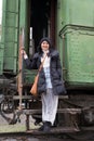 Asian woman tourist standing on steps of old vintage green train. Stalin's railroad car in the museum