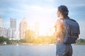 Asian woman tourist traveller backpack watching the beauty of the cityscape. at the scenic spot with a pond. at Bangkok Thailand Royalty Free Stock Photo