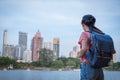 Asian woman tourist traveller backpack watching the beauty of the cityscape. at the scenic spot with a pond. at Bangkok Thailand Royalty Free Stock Photo