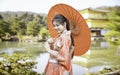 Asian woman tourists. Japanese girl wearing a kimono holding a red umbrella. Beautiful Female wearing traditional japanese kimono Royalty Free Stock Photo