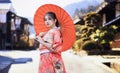 Asian woman tourists. Japanese girl wearing a kimono holding a red umbrella. Beautiful girl wearing traditional japanese kimono in Royalty Free Stock Photo