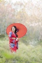 Asian woman tourists. Japanese girl wearing a red kimono wearing a red umbrella