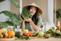 Asian woman in traditional conical hat making vegetable and fruit and microgreen sprouts salad