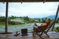 Asian woman travel nature. Relax read a book in the hammock. the balcony of the resort. View of the field on the Moutain in summer