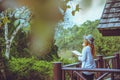 Asian woman travel relax. Natural park on the Moutain. Stand read a book on the balcony of the lodge