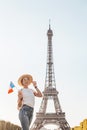 Asian woman traveler posing at Mars Field at the background of majestic Eiffel tower. Tourism and lifestyle in France and