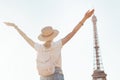 Asian woman traveler posing at Mars Field at the background of majestic Eiffel tower. Tourism and lifestyle in France and