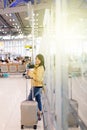 Asian woman traveler using mobile phone in airport,Lifestyle using cell phone connection concept,Feeling happy and smiling Royalty Free Stock Photo