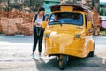 Asian woman travelers ask Tuk-Tuk driver about right direction on the map while exploring travel.