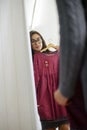 Asian woman trying clothing dress while shopping in clothes store during sale Royalty Free Stock Photo