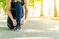 Asian woman tying shoe laces and getting ready for jogging outdoors Royalty Free Stock Photo