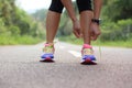 Asian woman tying shoelace on fossil forest trail Royalty Free Stock Photo