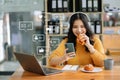 Asian woman typing smartphone, keyboard with laptop computer of Social media and Marketing virtual icons screen concept Royalty Free Stock Photo