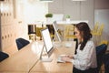 Asian woman typing on wireless keyboard in modern co-working space, with coffee mug, copy space Royalty Free Stock Photo