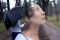 A asian woman with an umbrella standing in forest with trees. Image with double exposure effect