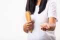 Woman unhappy weak hair problem her hold hairbrush and she showing damaged long loss hair from the brush on hand Royalty Free Stock Photo