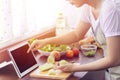 Asian woman use finger slide on tablet screen prepare ingredients for cooking follow cooking online video clip on website.
