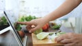 Asian woman use finger slide on tablet screen prepare ingredients for cooking follow cooking online video clip on website.