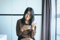 Asian woman using cell phone searching information and reading medicine label and prescription medications,Health care and people