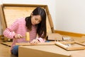 Asian woman using hammer for furniture assembling