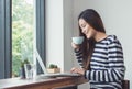 Asian woman using on laptop computer near window at cafe restaurant,Digital age lifestyle,using Technolgy concept,co working spa