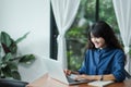 Asian woman using on laptop computer near window at cafe restaurant,Digital age lifestyle,using Technolgy concept,co working