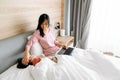 Asian woman using laptop while her daughter sleeping on bed Royalty Free Stock Photo