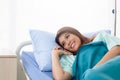 Asian woman patient using mobile phone on bed, admitted in hospital Royalty Free Stock Photo