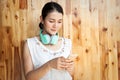 Asian woman using mobile phone with headphones on her neck. Technology and lifestyle