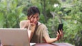 Asian woman using mobile phone selfie post in social media, female relax feeling happy showing shopping bags sitting on table in Royalty Free Stock Photo