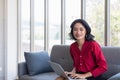 Asian woman using notebook computer on sofa Royalty Free Stock Photo