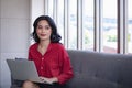 Asian woman using notebook computer on sofa Royalty Free Stock Photo