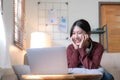 Asian woman are using notebook computers and wear headphones for online meetings and working from home. Royalty Free Stock Photo