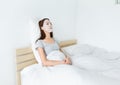 Asian woman using paper mask on face and lying down on the bed